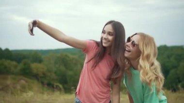 Güzel kızlar telefonu doğada fotoğraf çekmek.