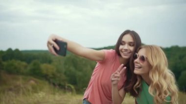 Güzel kızlar telefonu doğada fotoğraf çekmek.
