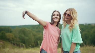 Güzel kızlar telefonu doğada fotoğraf çekmek.