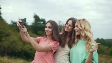 Güzel kızlar telefonu doğada fotoğraf çekmek.