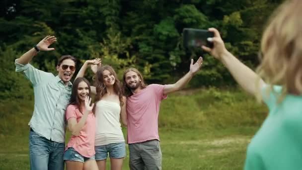 Amigos felizes tirando fotos no telefone na natureza . — Vídeo de Stock
