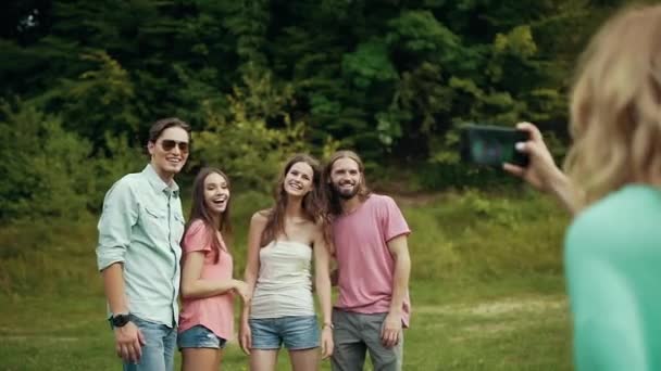 Amigos felizes tirando fotos no telefone na natureza . — Vídeo de Stock