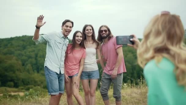 Amigos felizes tirando fotos no telefone na natureza . — Vídeo de Stock