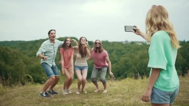 Amigos saltando y divirtiéndose mientras toman fotos en la naturaleza — Vídeos de Stock