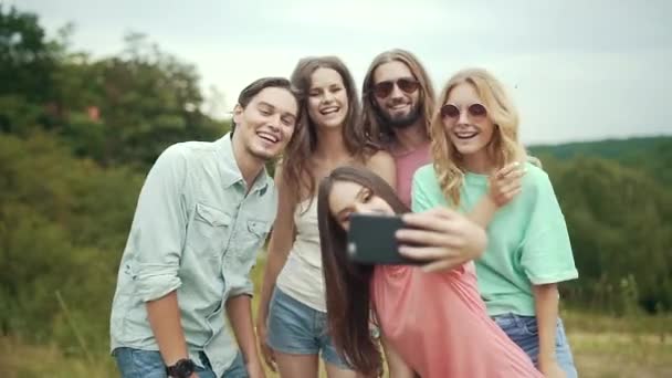Sorridente giovani uomini e donne scattare foto in natura — Video Stock