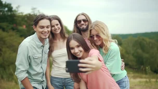 Sorridente giovani uomini e donne scattare foto in natura — Video Stock