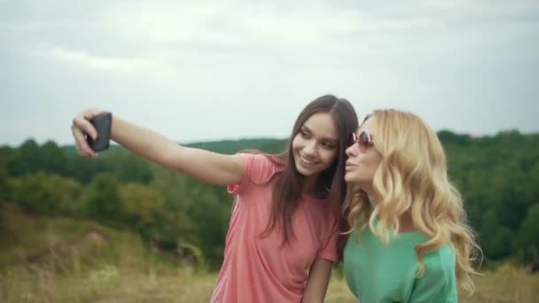 Belles filles prenant des photos au téléphone dans la nature . — Video