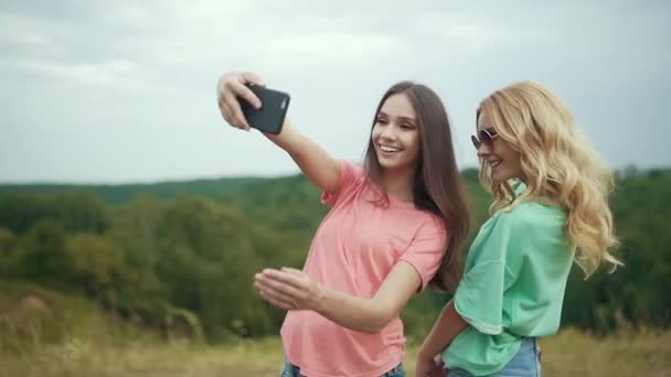 Meninas bonitas tirando fotos no telefone na natureza . — Vídeo de Stock