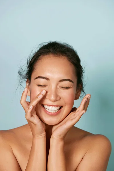 Güzel surat. Gülümseyen Asyalı kadın sağlıklı deri portresine dokunuyor. — Stok fotoğraf