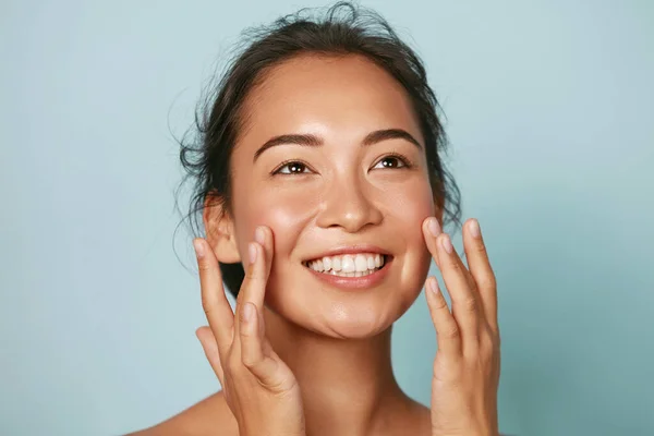 Güzel surat. Gülümseyen Asyalı kadın sağlıklı deri portresine dokunuyor. — Stok fotoğraf