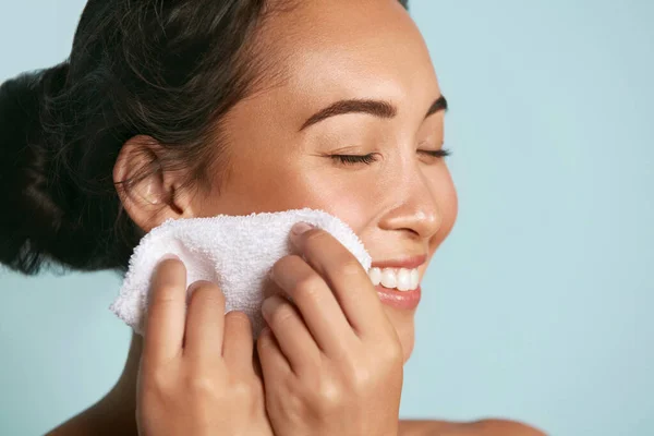 Женщина очищает кожу лица полотенцем после мытья портрета лица — стоковое фото