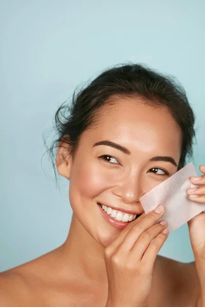 Cara cuidados com a pele. Mulher sorridente usando óleo blotting retrato de papel — Fotografia de Stock