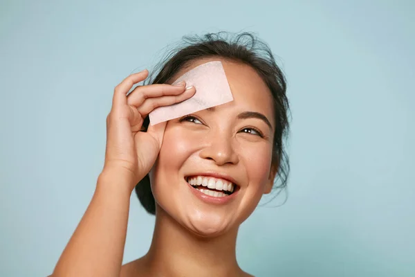 Cuidado de la piel. Mujer sonriente usando papel de borrado de aceite retrato —  Fotos de Stock