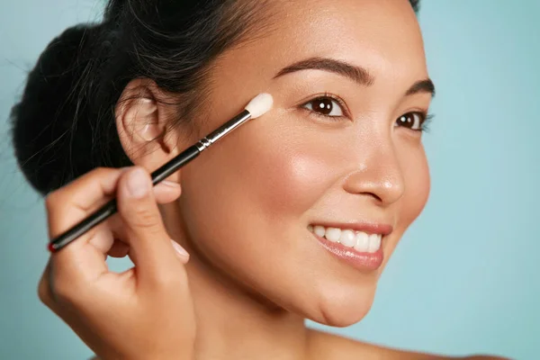 Cantik. Wanita menerapkan makeup pada mata dengan sikat kosmetik — Stok Foto