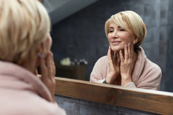 Skincare Routine Mature Woman Touches Face Skin Front Mirror Reflection — Stock Photo, Image