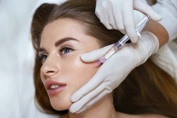 美容注射 美容室で若い女性の顔のための抗老化非外科的治療 シリンジと美容師の手 — ストック写真