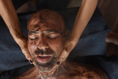 Spa masajı. Erkek için Cilt Bakımı Tedavisi. Çamurlu Güzellik Masajcısı. Doğal Kozmetik Prosedürü Üzerine Gevşek Model.