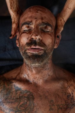 Spa masajı. Erkek için Cilt Bakımı Tedavisi. Çamurlu Güzellik Masajcısı. Doğal Kozmetik Prosedürü Üzerine Gevşek Model.