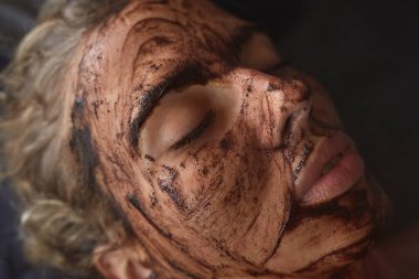 Spa Suratlı Maske. Cilt Bakımı için Güzellik Tedavisi. Güzellik Uzmanı, Kadın Yüzüne Masaj Yapıyor. Doğal Kozmetik Prosedürü Üzerine Gevşek Model.