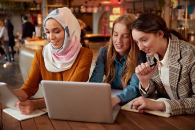 Arkadaşız. Kadınlar Kafe 'de Buluşuyor. Bistro 'da laptoplu ve tabletli üç genç kız çalışıyor. Farklılık Meslektaşları Restoranda Zaman Geçiriyorlar. Yaşam Tarzı Olarak Bağımsız. 