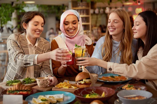 昼食だ カフェポートレートの若い女性 笑顔のグループ多民族の女の子はカクテルで応援します ライフスタイルの一部としてレストランで会う友人 — ストック写真