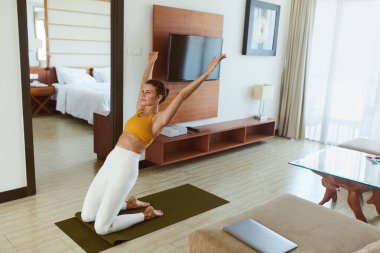 Yoga egzersizi. Geri Bükümlü Kadın Asana. Ustrasana Pozu Çalışan Kadın. Esmer kadın diz çöküp arkasını yaslıyor. Formda ve sağlıklı kalmak için spor rutini. 