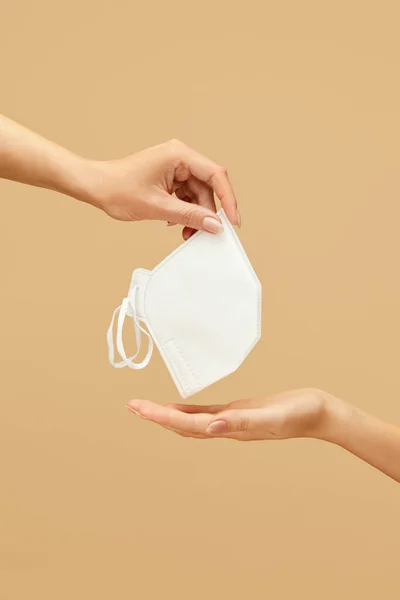 Respirator. Female Hand With Personal Protective Equipment On Beige Background. Using Breath Protection For Virus And Bacterial Infection Prevention.