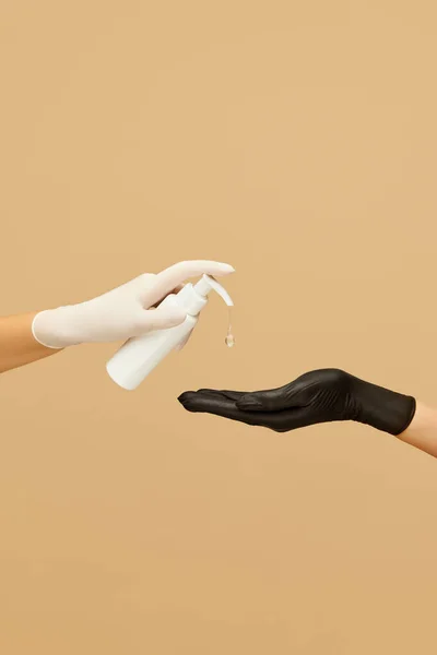 衛生兵 女性の手で白手袋保持ジェルサニタイザーボトルでベージュの背景 ウイルス予防と健康維持のための手を洗う — ストック写真