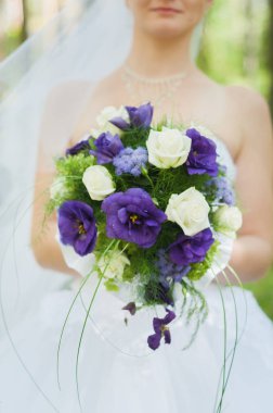 düğün töreni güneş parkta güzel bir buket mor ve beyaz çiçek tutan sonra gelin