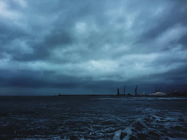 島から遠く離れた夜の嵐の海と灯台の和解 ロイヤリティフリーのストック写真