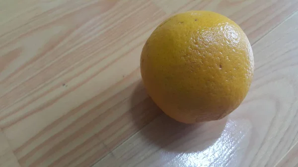 Vista de cerca de naranjas sobre suelo de madera con fondo de madera . — Foto de Stock