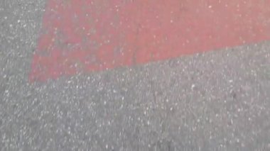 Ortadaki kırmızı parçalarla kaplı gri renkli yolda yürüyüşün 4k görüntüsü