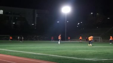 Chuncheon, Güney Kore - Ekim, 25-2019: gece futbol maçı izleniyor. Oyuncular yeşil çimlerin üzerinde projektörler altında futbol oynuyorlar.