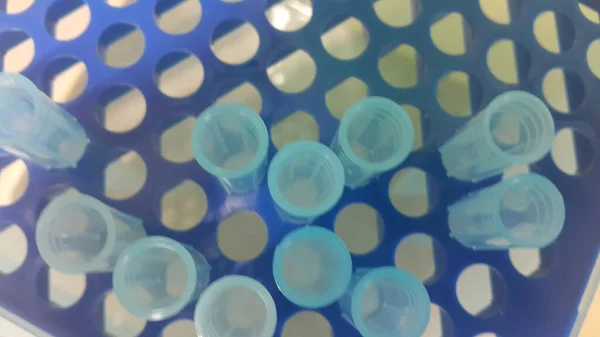 Vista de cerca de las puntas de micro litros azules en la caja microtip con agujeros vacíos . —  Fotos de Stock