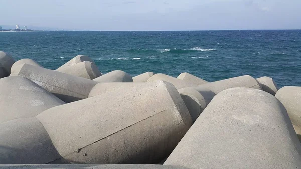 Vista cercana de las piedras de tetrápodo en la orilla del mar para evitar la ersosión costera . —  Fotos de Stock