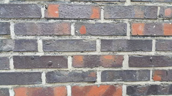 Un arrière-plan d'un vieux mur de briques extérieures altérées au soleil . — Photo