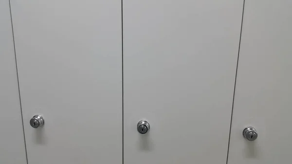 Перспективный вид шкафчиков или шкафов в ряд с белыми дверями — стоковое фото