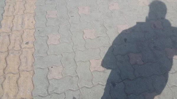 Silueta: La sombra de un hombre en el suelo de hormigón de color rojo — Foto de Stock