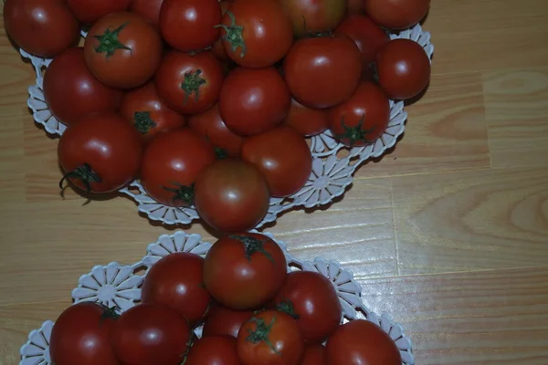 Vue rapprochée de tomates rouges dans un panier blanc sur un plancher de bois au marché — Photo