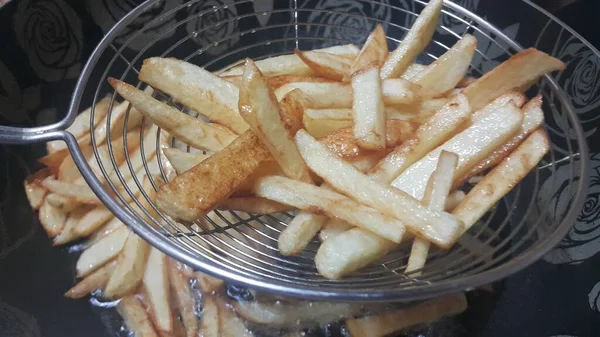 Προβολή closeup πατάτες τηγανιτές ή ψητές πατάτες μπαστούνια στο μέταλλο βλέμμα — Φωτογραφία Αρχείου
