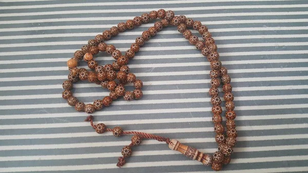 Beautiful wooden prayer beads or rosary with a striped background