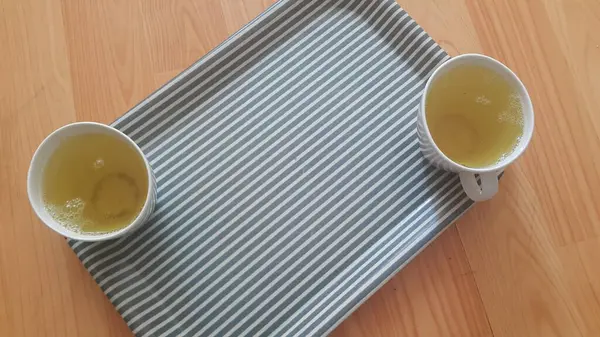 Vista superior del té verde en una taza colocada en una bandeja sobre un piso de madera — Foto de Stock