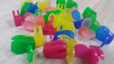 Ahşap bir zemin üzerine yerleştirilen renkli küçük holding klipleri bir sürü