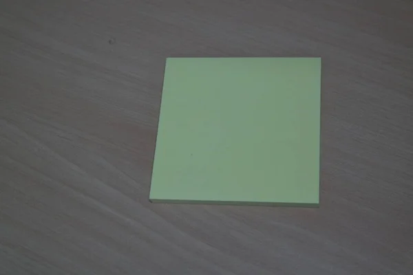 Papel adhesivo amarillo colocado en una mesa de madera — Foto de Stock