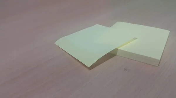 Gelbes, klebriges Notizpapier auf einem Holztisch — Stockfoto