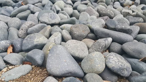 Kamyki kamienne, małe, zaokrąglone, gładkie kamienie. Tekst w tle tekstury — Zdjęcie stockowe