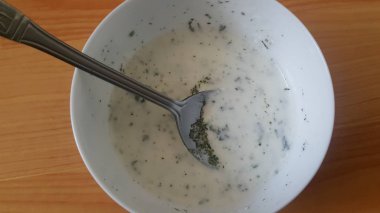 Gümüş kaşıkla beyaz seramik kasede sade lor veya yoğurt veya dahi yakın