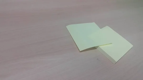 Papel adhesivo amarillo colocado en una mesa de madera — Foto de Stock