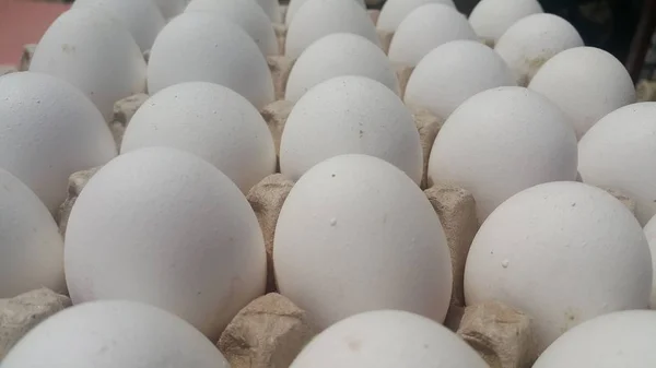 Свежие куриные белые яйца в коробке для яиц на рынке — стоковое фото