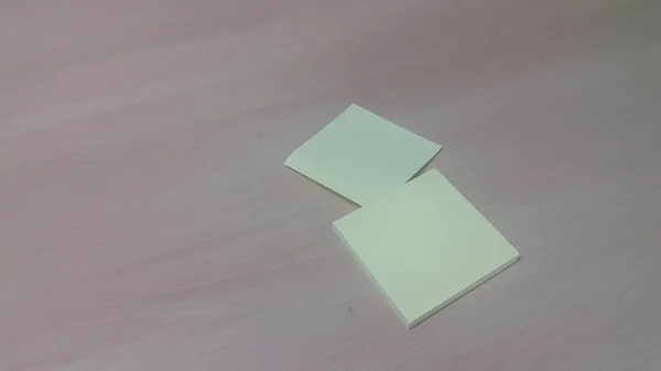 Gelbes, klebriges Notizpapier auf einem Holztisch — Stockfoto
